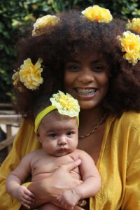 Black mother and baby wearing yellow flowers in their hair